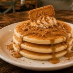 Biscoff pancakes topped with Biscoff spread, crushed Biscoff cookies, and whipped cream